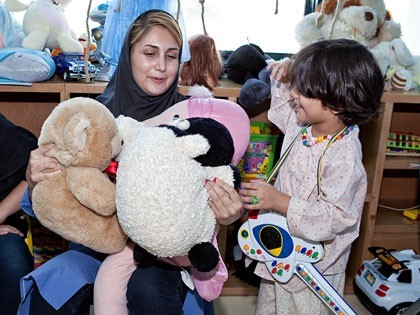 MAHAK child with one of psychologists The child playing and enjoying the psychologist's company in the playroom